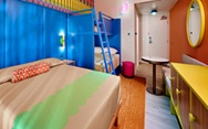 Colorful hotel room with a bed and bunkbeds