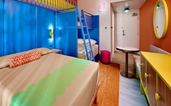 Colorful hotel room with bed and bunkbeds